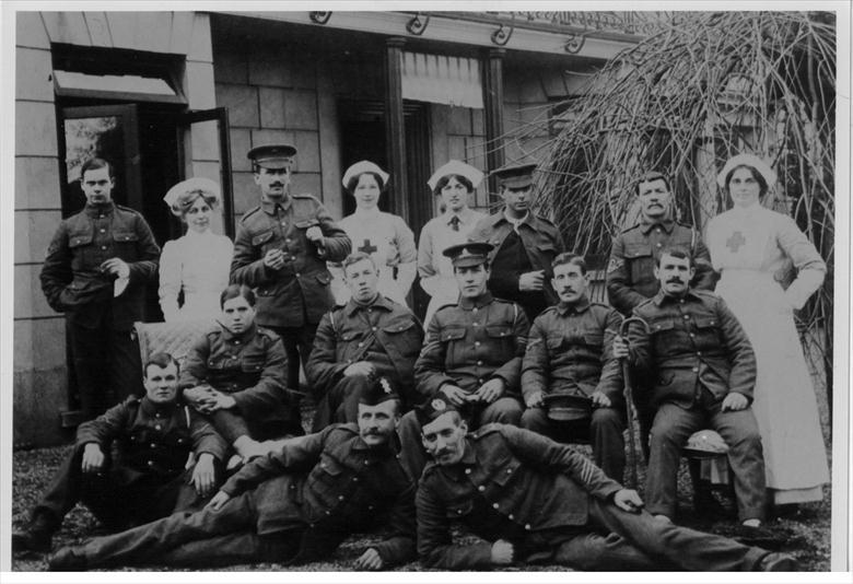 Photograph. Convalescing soldiers and staff outside the Red Cross Voluntary Aid Detachment Hospital, Wellingtonia, 113 Mundesley Road, North Walsham during WW1 (North Walsham Archive).