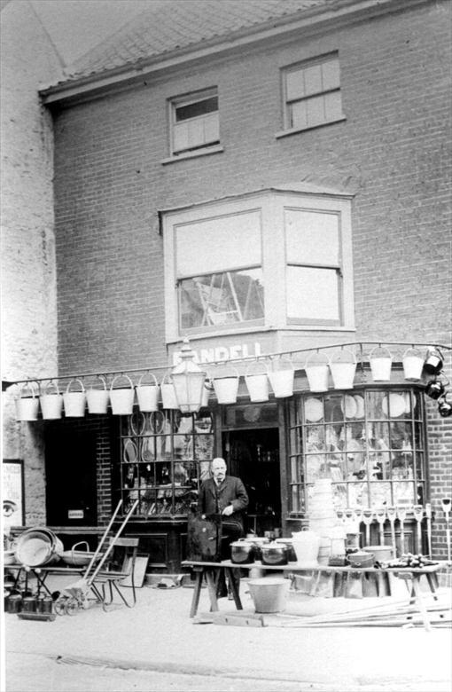Photograph. Fred Randell outside his original shop premises, Market Place, North Walsham (North Walsham Archive).