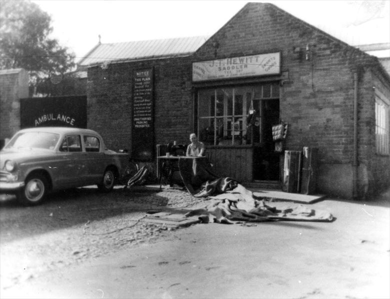 Photograph. Jack Hewitt outside his Saddler's Shop on Church Plain North Walsham (North Walsham Archive).