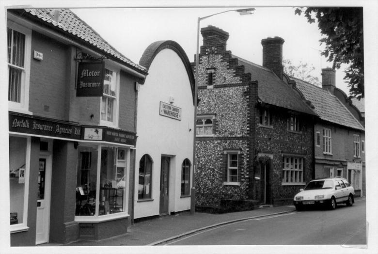 Photograph. Kings Arms Street, North Walsham; "Norfolk Motor Insurance" left; the gable end of the old "Picturedrome" centre. Photo R.M.Ling(2) (North Walsham Archive).