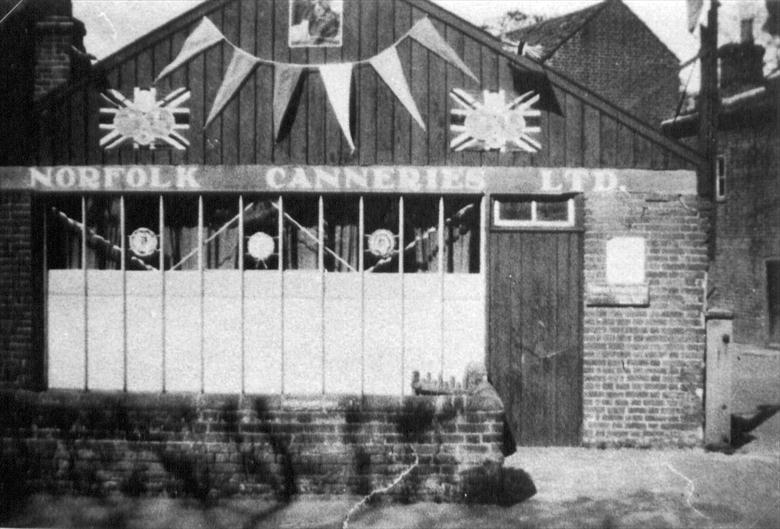 Photograph. Norfolk Canneries Ltd., Park Hall, New road, North Walsham. Decorated to celebrate the 1937 Coronation of King George VI and Queen Elizabeth. (North Walsham Archive).